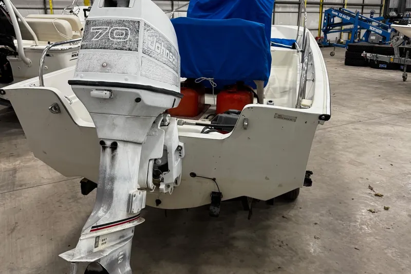 Slide: The Image of 1991 Boston Whaler 17 Montauk with Johnson 70 outboard motor in a garage. - 3
