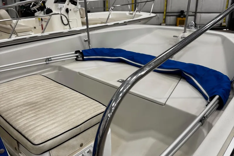 Slide: The Image of 1991 Boston Whaler 17 Montauk boat interior with cushioned seating and blue cover. - 7