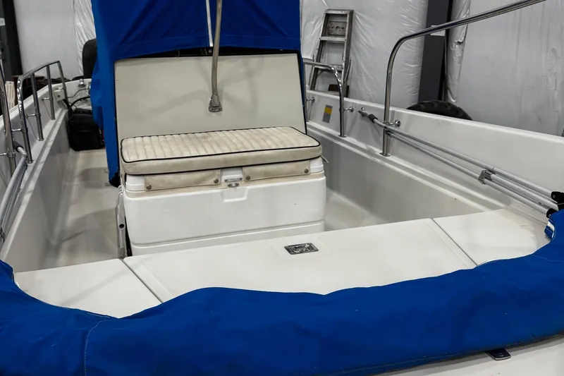 Slide: The Image of 1991 Boston Whaler 17 Montauk interior with blue cover and seating. - 8