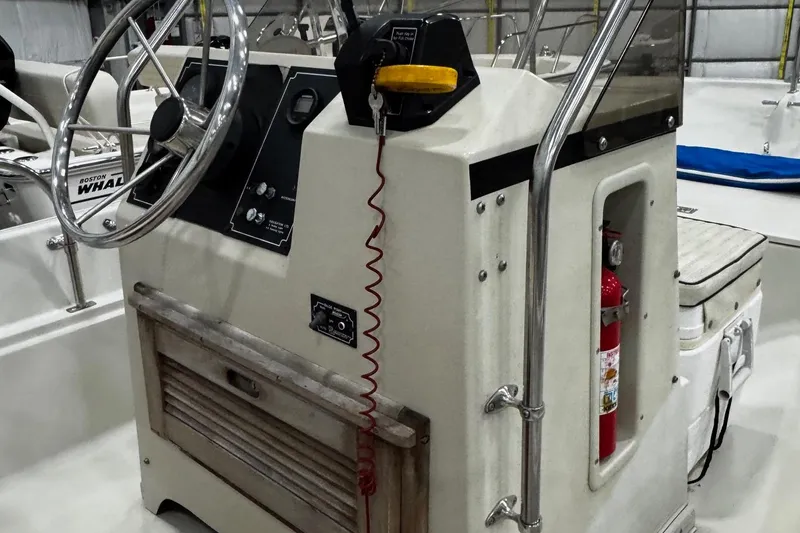 Slide: The Image of 1991 Boston Whaler 17 Montauk boat console with steering wheel and fire extinguisher. - 9