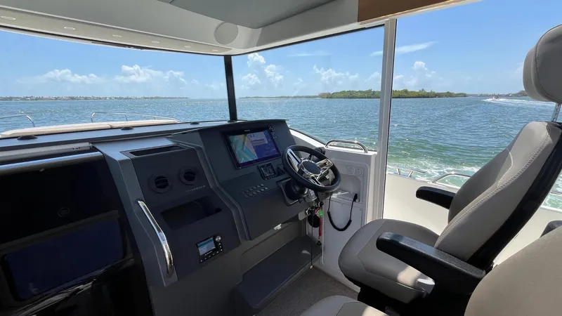 Slide: The Image of Interior of 2025 Nimbus Commuter 11 boat, featuring modern helm and scenic ocean view. - 28