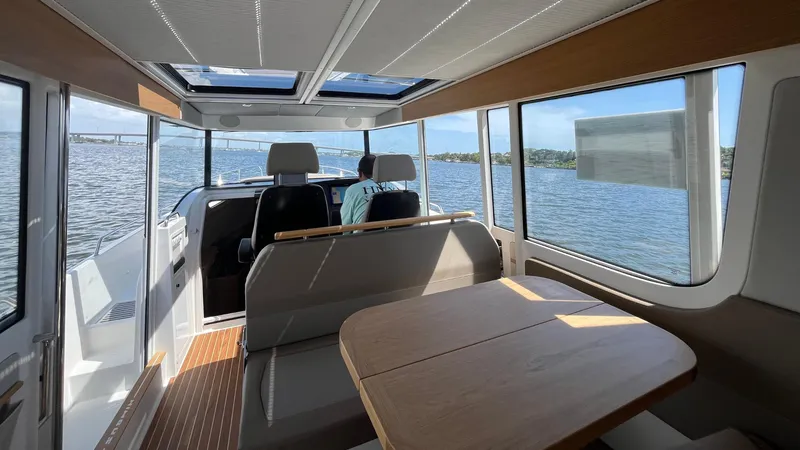 Slide: The Image of Interior of 2025 Nimbus Commuter 11 boat with panoramic windows and seating area. - 19