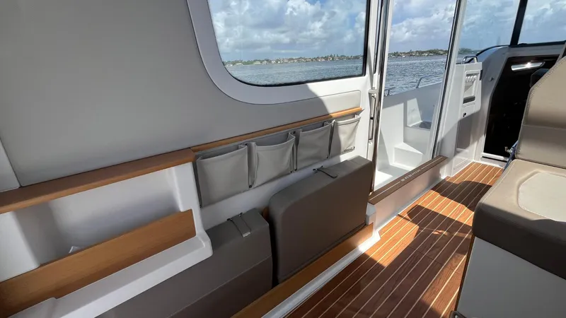 Slide: The Image of Interior of 2025 Nimbus Commuter 11 boat with wooden flooring and seating. - 22