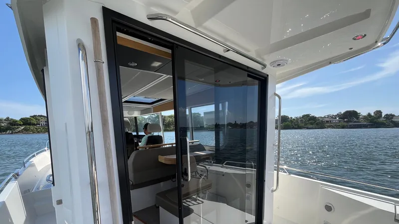 Slide: The Image of 2025 Nimbus Commuter 11 #086 boat with glass doors, docked by a scenic waterfront. - 15
