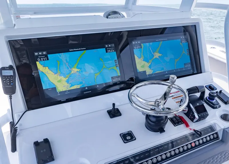 Slide: The Image of 2025 Invincible 43 Open Fisherman helm with dual navigation screens and steering wheel. - 16