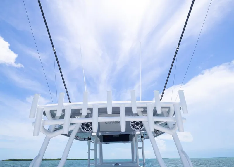 Slide: The Image of 2025 Invincible 43 Open Fisherman boat with fishing rod holders against a blue sky. - 29