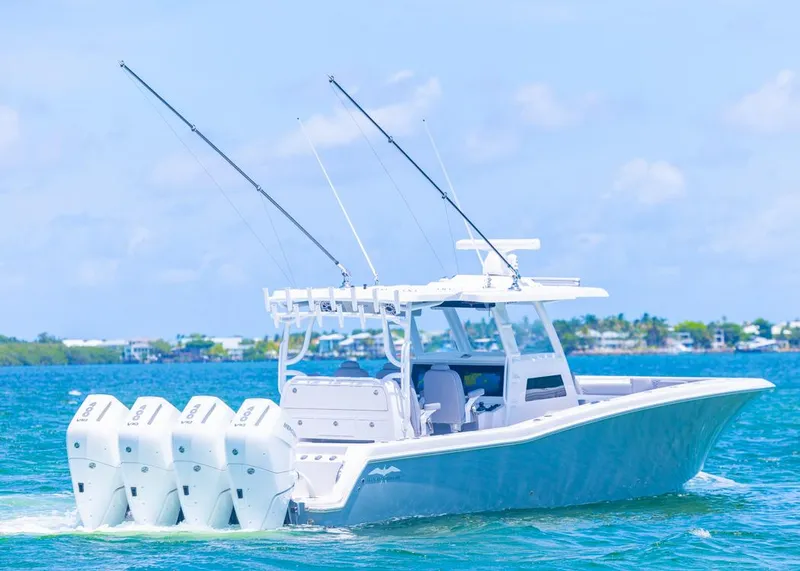 Slide: The Image of 2025 Invincible 43 Open Fisherman boat cruising on blue water with four engines. - 44