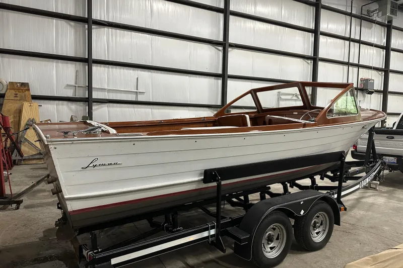 Slide: The Image of 1961 Lyman 21 Runabout boat on trailer in a warehouse setting. - 1