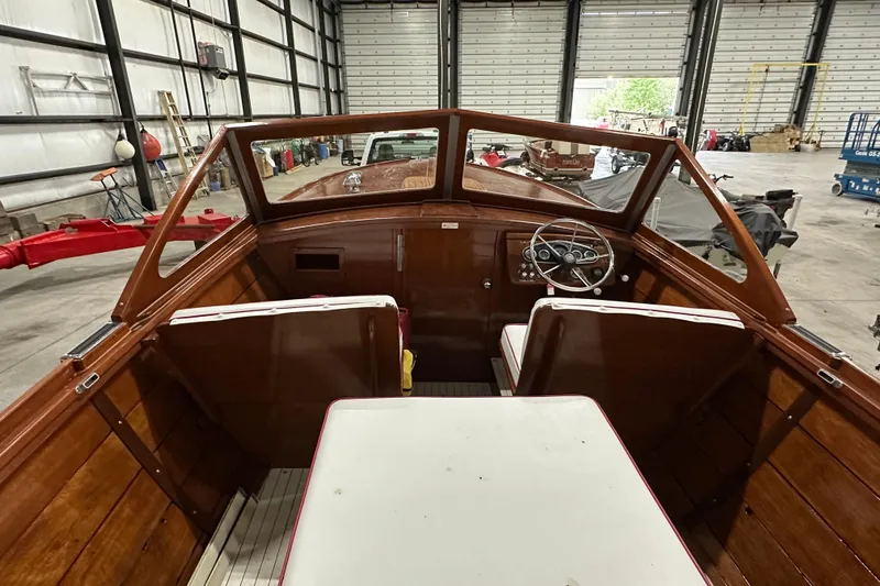 Slide: The Image of 1961 Lyman 21 Runabout boat interior with wooden finish in a warehouse setting. - 11