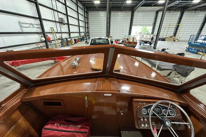 Slide: The Image of 1961 Lyman 21 Runabout boat interior with wooden dashboard in a spacious garage. - 13