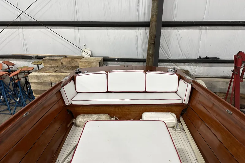 Slide: The Image of 1961 Lyman 21 Runabout boat interior with white cushioned seating and wooden finish. - 17