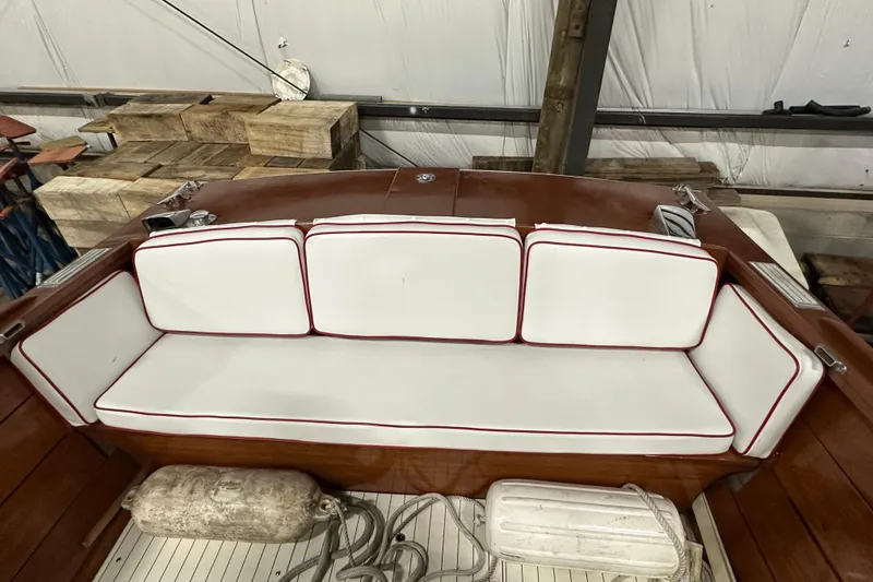 Slide: The Image of 1961 Lyman 21 Runabout boat interior with white cushioned seating and wooden deck. - 18