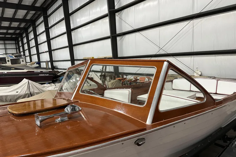 Slide: The Image of 1961 Lyman 21 Runabout boat with wooden deck in indoor storage. - 3