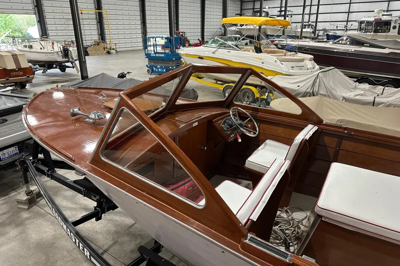 Slide: The Image of 1961 Lyman 21 Runabout boat with wooden interior in a storage facility. - 6