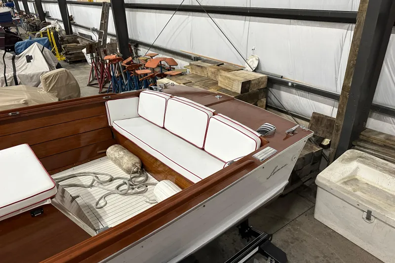 Slide: The Image of 1961 Lyman 21 Runabout boat interior with white and red-trimmed seating in a workshop. - 9