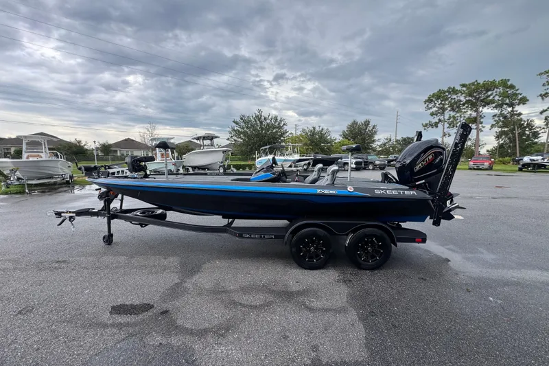 Slide: The Image of 2026 Skeeter ZXE20 boat on trailer in parking lot under cloudy sky. - 6