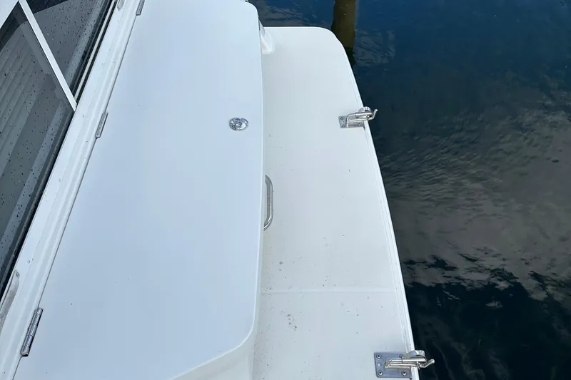 Slide: The Image of 1997 Carver 325 Motor Yacht deck, featuring white surface and metal fixtures by the water. - 10