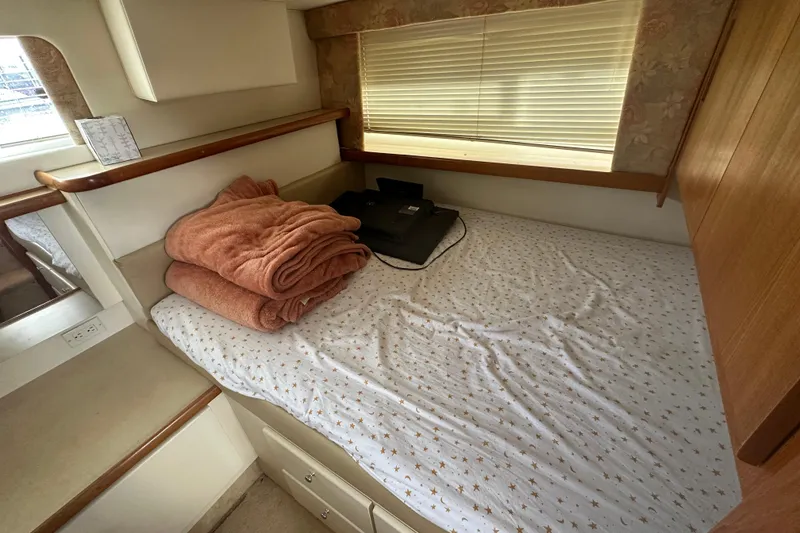Slide: The Image of Cozy cabin interior of 1997 Carver 325 Motor Yacht with bed and folded blankets. - 35