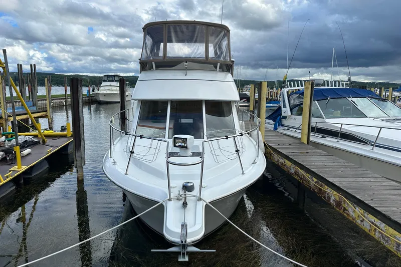 Slide: The Image of 1997 Carver 325 Motor Yacht docked at marina under cloudy sky. - 2