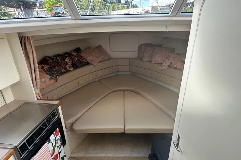 Slide: The Image of 1997 Carver 325 Motor Yacht interior with cozy seating and floral cushions. - 25