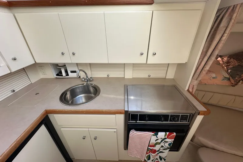 Slide: The Image of 1997 Carver 325 Motor Yacht kitchen with sink, stove, and cabinets. - 28