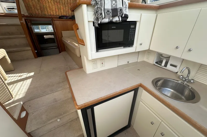 Slide: The Image of 1997 Carver 325 Motor Yacht interior with kitchenette, microwave, sink, and stairs. - 29