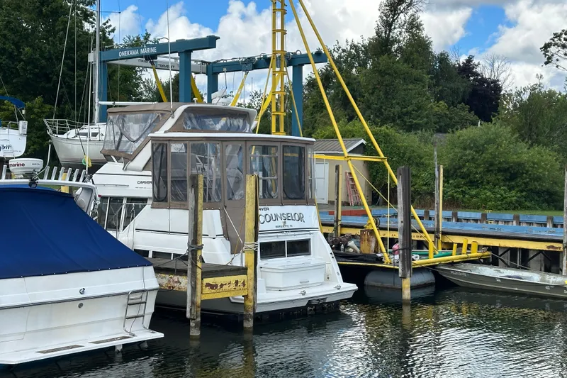 Slide: The Image of 1997 Carver 325 Motor Yacht docked at Onekama Marine, surrounded by lush greenery. - 5