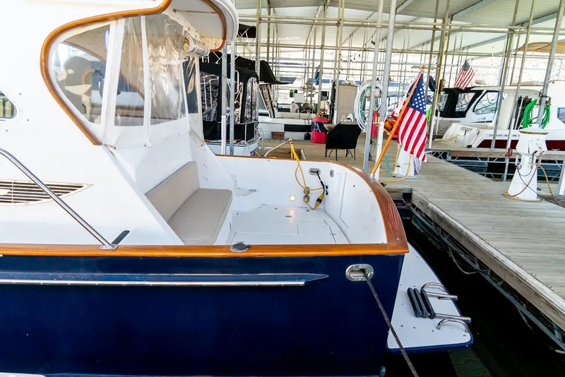 Slide: The Image of 2002 Legacy 34 Express boat docked at a marina with American flag. - 10