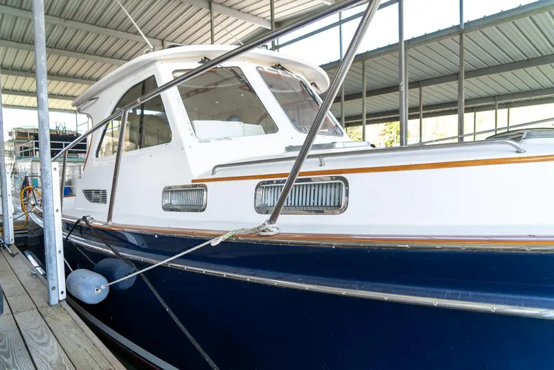 Slide: The Image of 2002 Legacy 34 Express boat docked in a covered marina. - 12