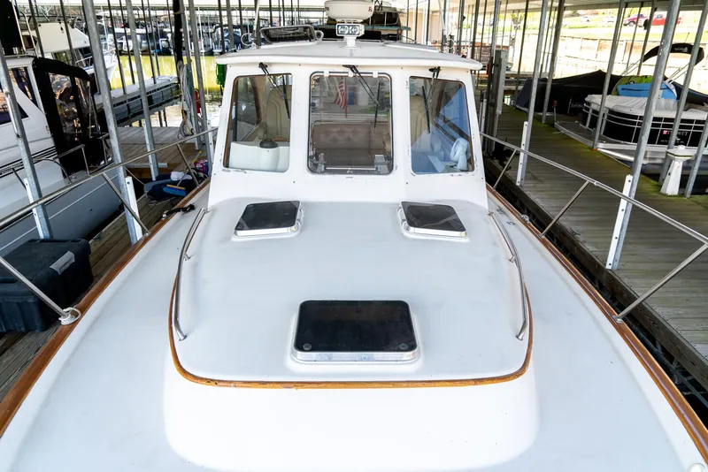 Slide: The Image of 2002 Legacy 34 Express boat docked in a marina, front view. - 16