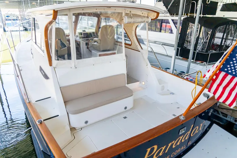 Slide: The Image of 2002 Legacy 34 Express boat with seating area and American flag. - 21