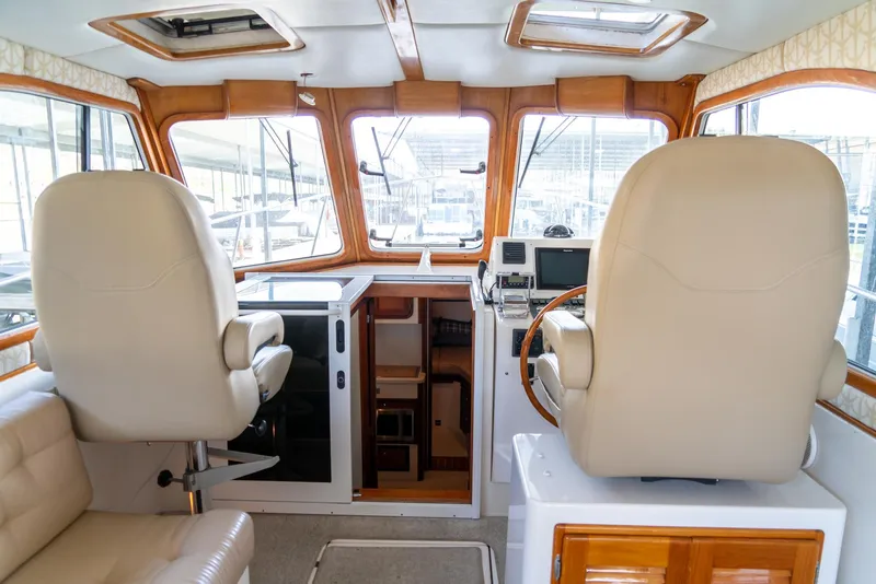 Slide: The Image of 2002 Legacy 34 Express boat interior with helm station and seating. - 24