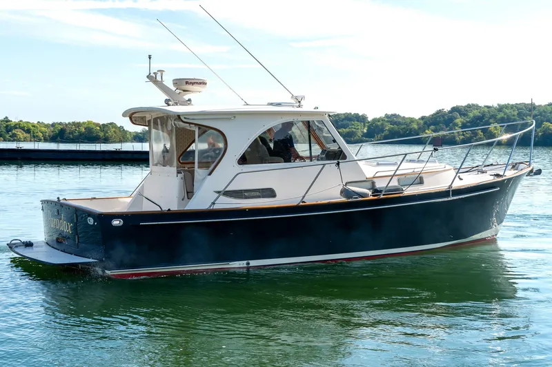 Slide: The Image of 2002 Legacy 34 Express boat on calm water, side view. - 3