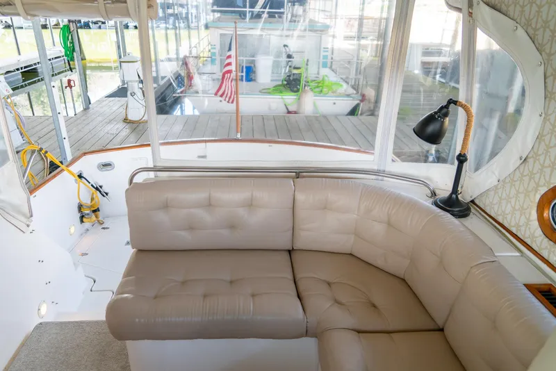 Slide: The Image of Interior of 2002 Legacy 34 Express yacht with beige leather seating and dock view. - 30