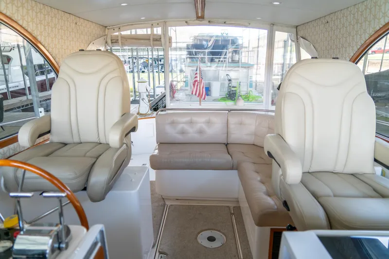 Slide: The Image of Interior of a 2002 Legacy 34 Express boat with white leather seating and helm chairs. - 31