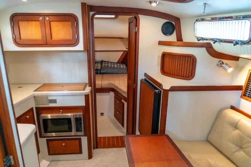 Slide: The Image of Interior of 2002 Legacy 34 Express boat with kitchenette, seating area, and sleeping quarters. - 32