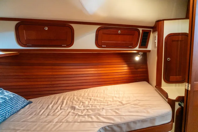 Slide: The Image of 2002 Legacy 34 Express boat cabin with wooden interior and bed. - 40