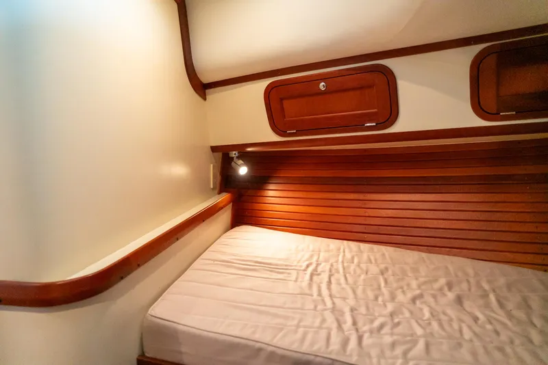 Slide: The Image of 2002 Legacy 34 Express cabin with wooden accents and cozy bed. - 41