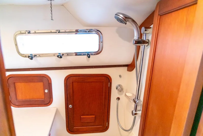 Slide: The Image of 2002 Legacy 34 Express boat bathroom with wooden cabinets and shower. - 43