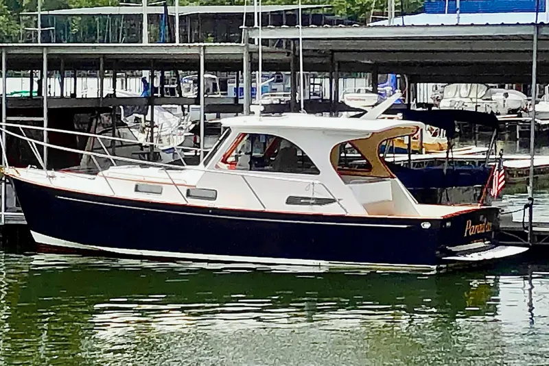 Slide: The Image of 2002 Legacy 34 Express boat docked in a marina. - 6