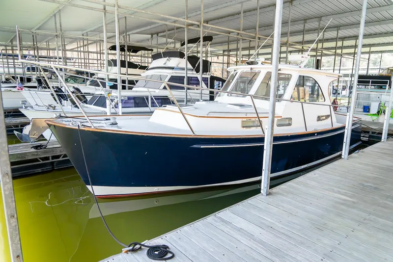Slide: The Image of 2002 Legacy 34 Express boat docked in a marina. - 7