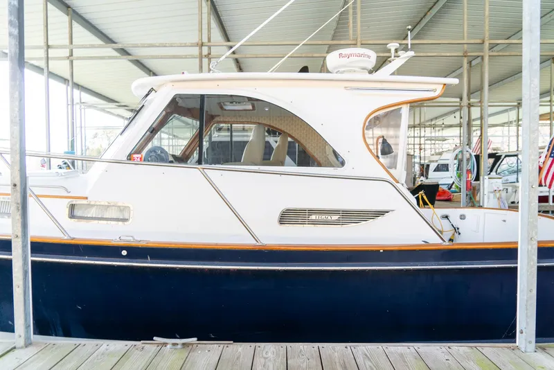 Slide: The Image of 2002 Legacy 34 Express boat docked in a covered marina. - 9