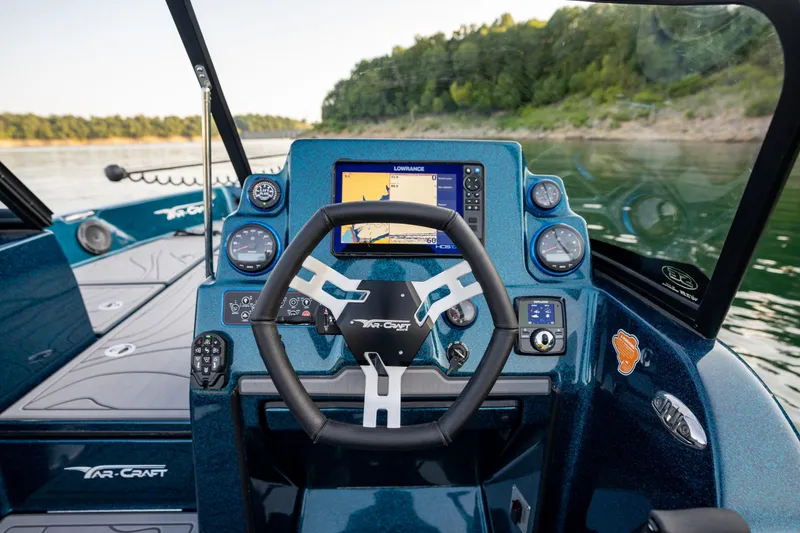Slide: The Image of 2025 Yar-Craft 210 TFX SP boat dashboard with steering wheel and navigation system. - 2