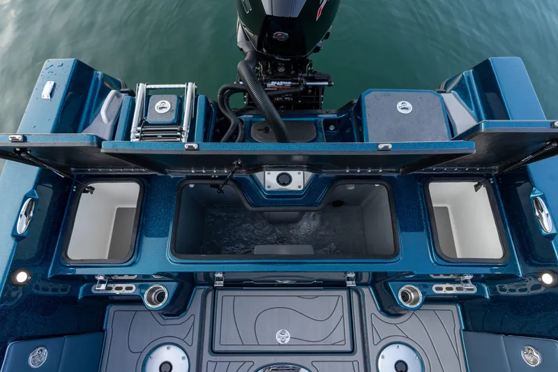 Slide: The Image of 2025 Yar-Craft 210 TFX SP boat interior with open compartments and motor, on water. - 6