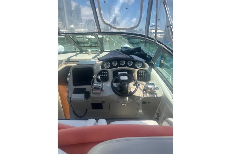 Slide: The Image of 2006 Sea Ray 340 Sundancer helm with steering wheel and control panel, docked in marina. - 17