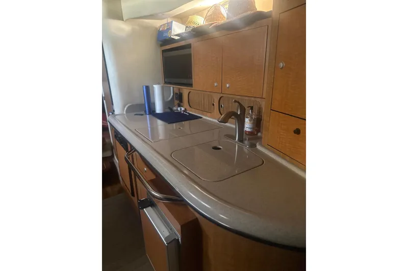 Slide: The Image of 2006 Sea Ray 340 Sundancer kitchen area with sink, cabinets, and countertop. - 25