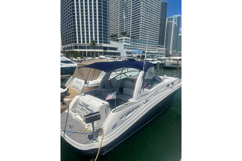 Slide: The Image of 2006 Sea Ray 340 Sundancer docked in marina with city skyline backdrop. - 4