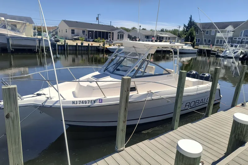 The Image of 1995 Robalo 2440 Walkaround boat docked in a marina. - 1