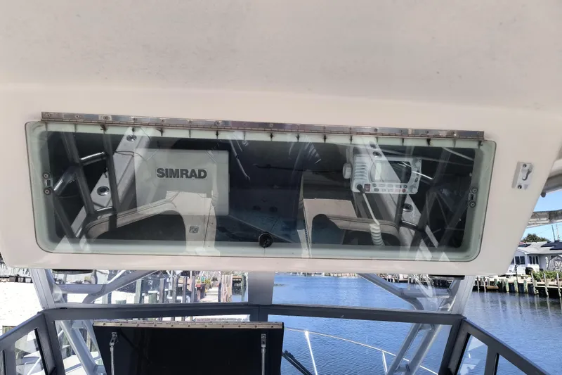 Slide: The Image of 1995 Robalo 2440 Walkaround boat with Simrad electronics, docked by the water. - 10