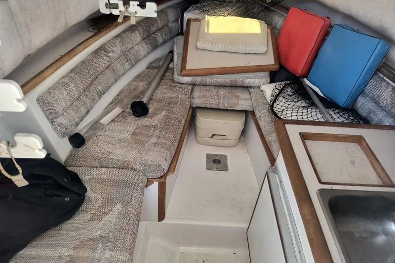 Slide: The Image of Interior of a 1995 Robalo 2440 Walkaround boat with seating and storage. - 11